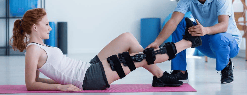 Physiotherapist assisting a patient with mobility exercises during postoperative rehabilitation.